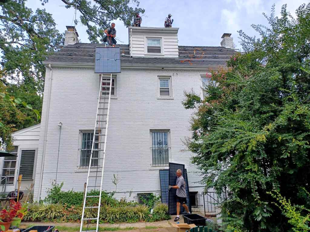 Four solar installers in the process of a rooftop installation in Washington, D.C..