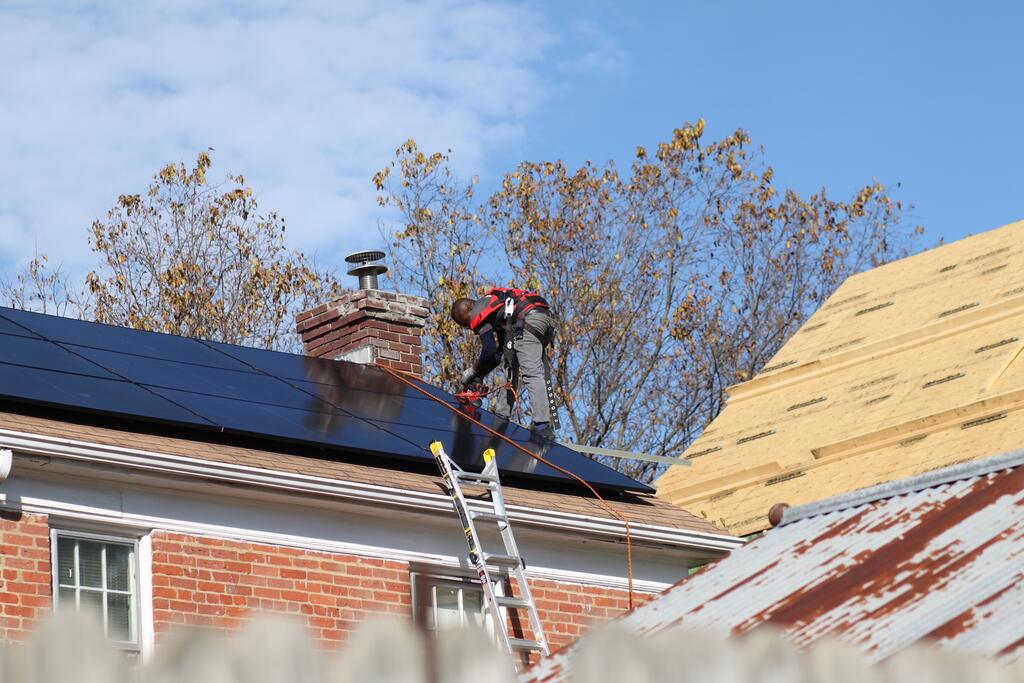 An Uprise solar installer putting solar on a roof in the Manor Park neighborhood in Northeast Washington, D.C..