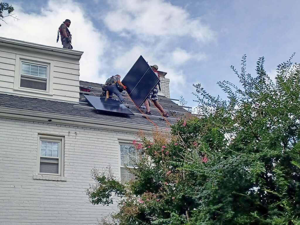 Three solar installers on a roof in Washington, D.C..