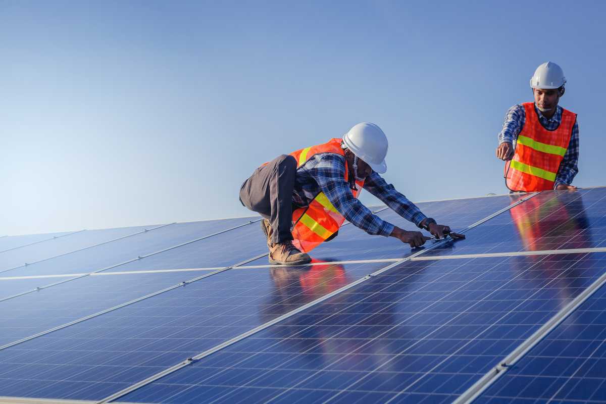 two solar installers on a roof installing solar panels