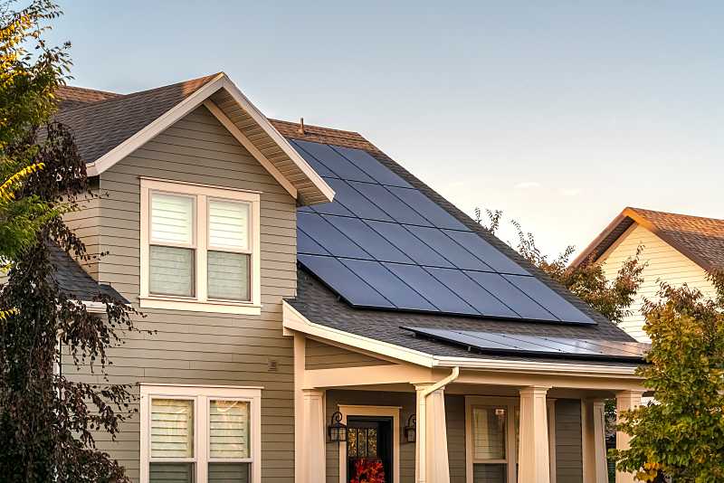 two story home with solar panels installed on the roof