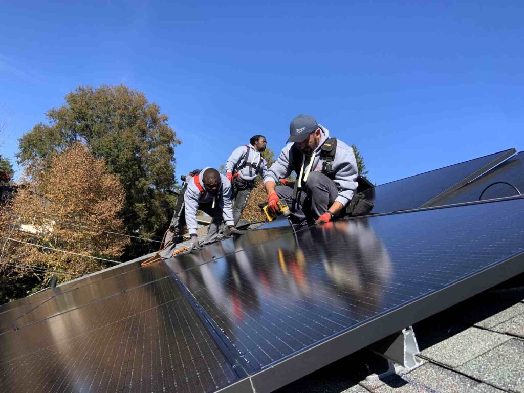 Three solar workers bolting in a panel.