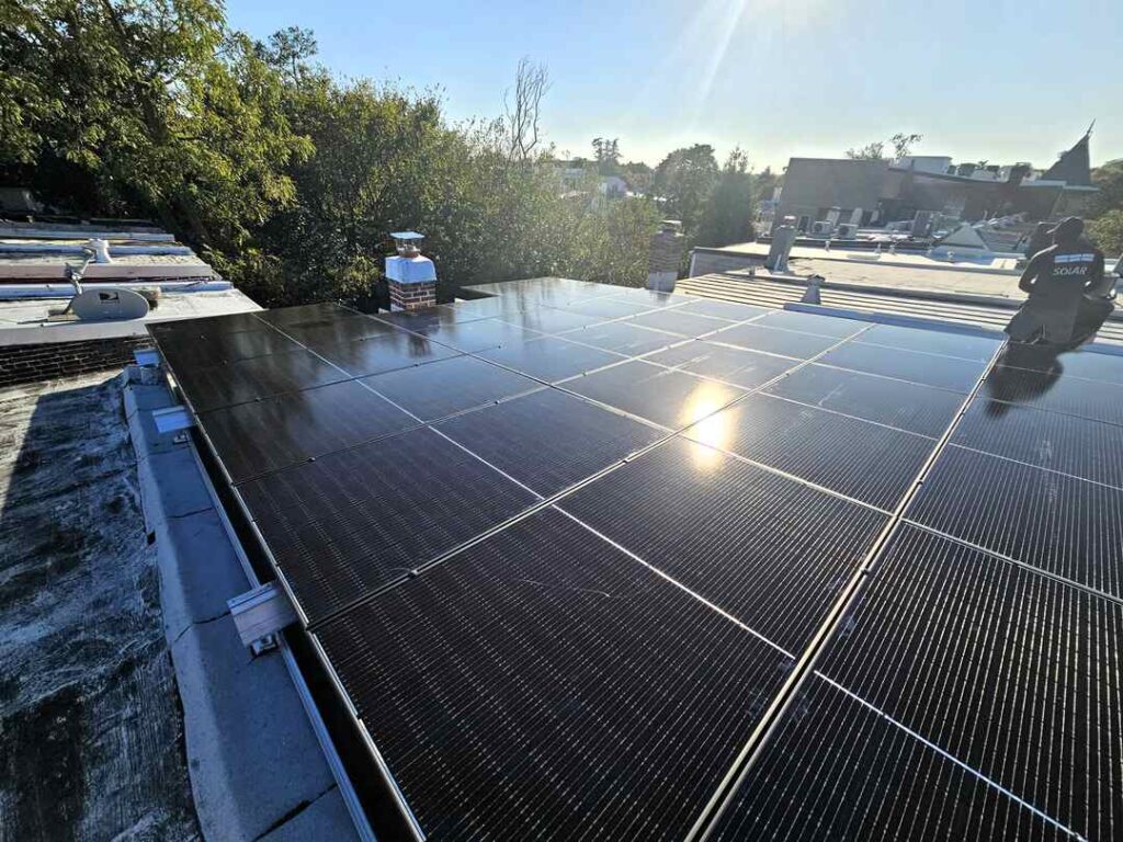 Sun shining on solar panels on a flat roof.