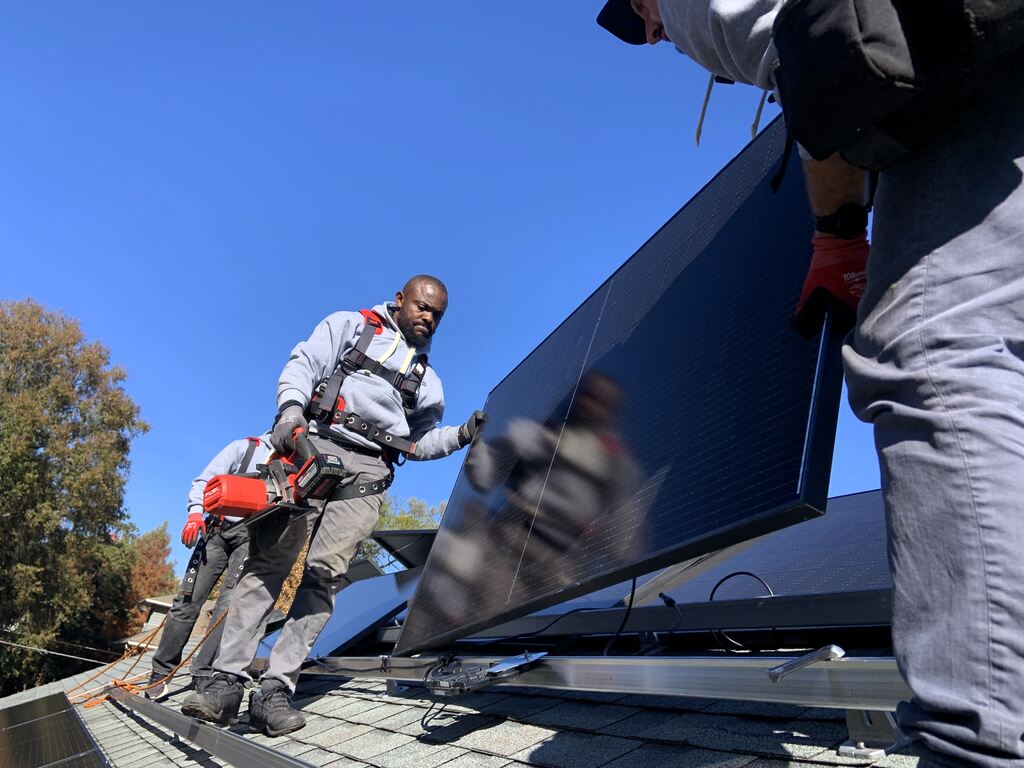 Two installers holding a solar panel.