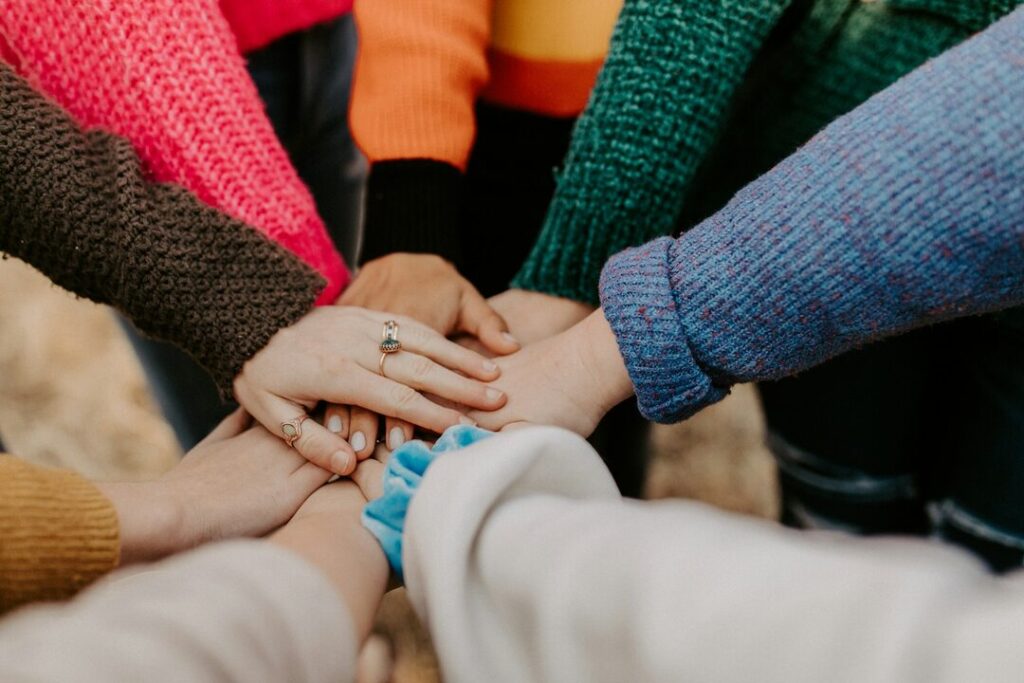 Women's hands stacked together.