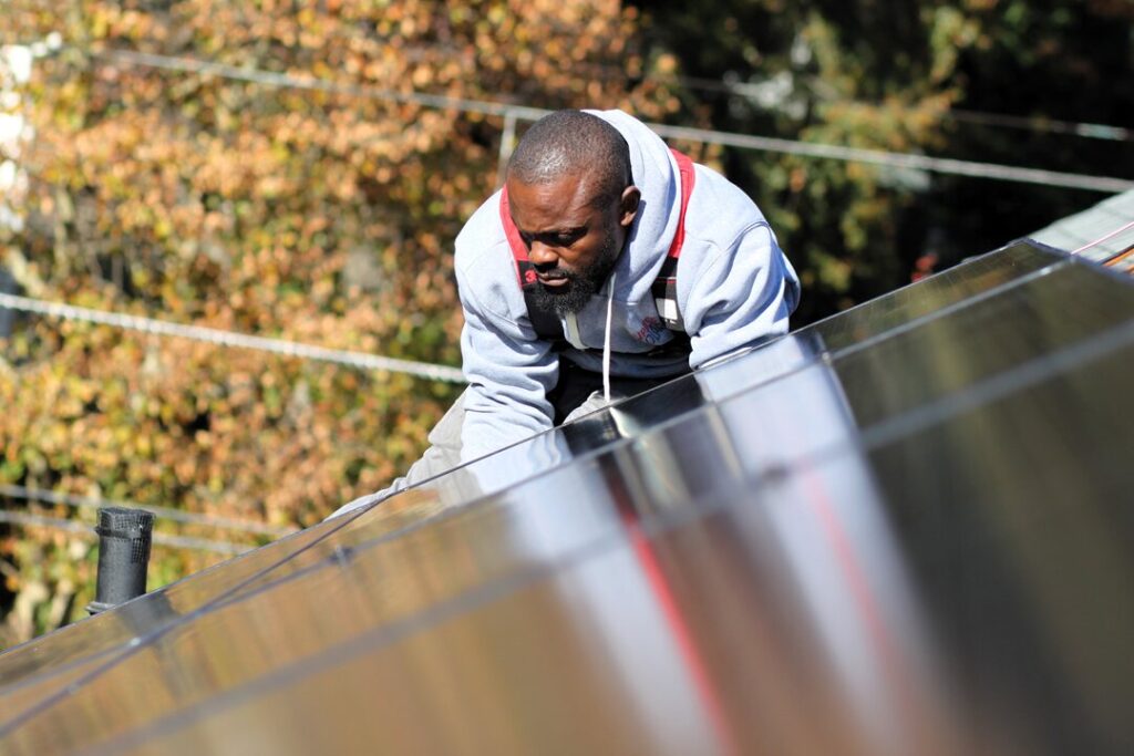 A man installs a solar panel.