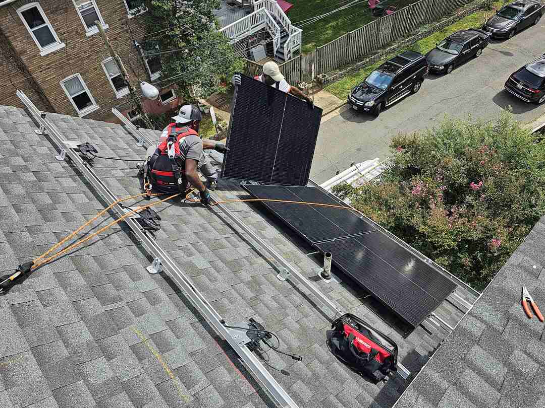 Two Uprise Solar installers attach a solar panel to the racking.