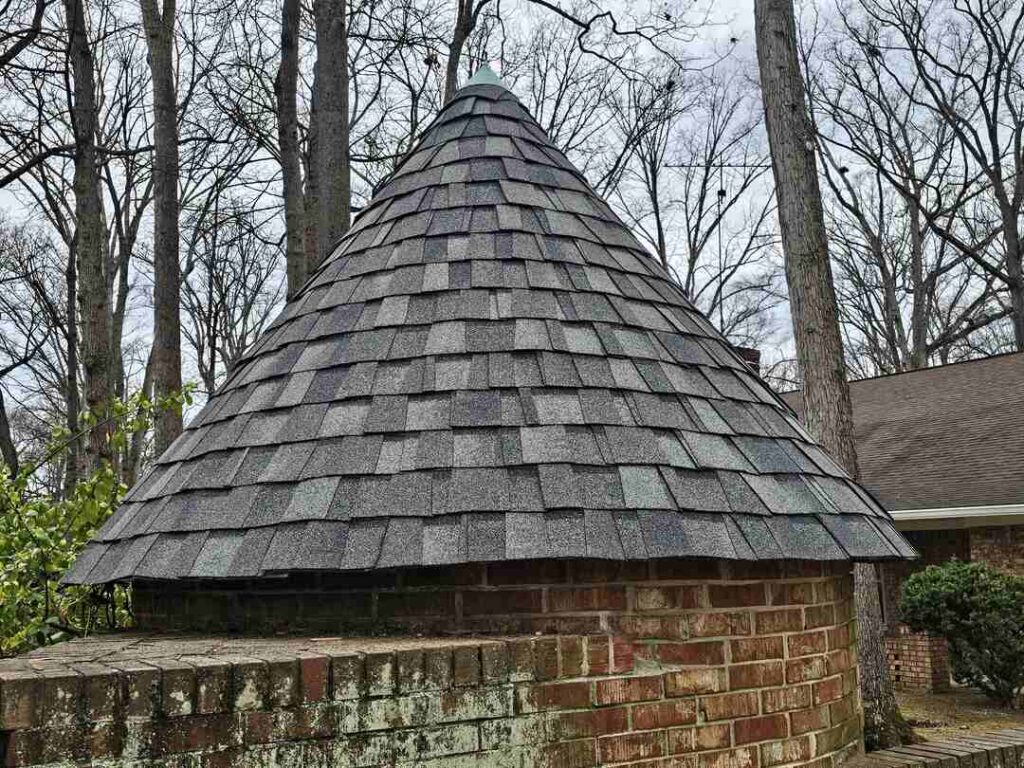 Close-up of new architectural shingles on a round shed in this roofing project.