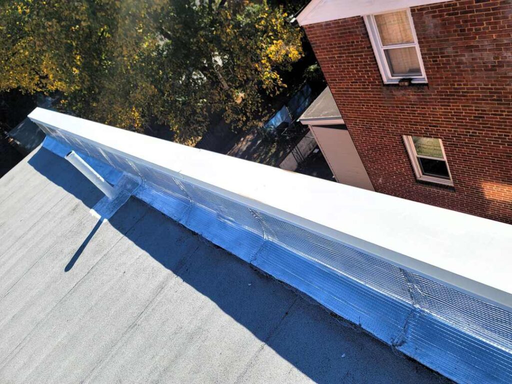 This roofing project includes aluminum flashing with a white coping cap.