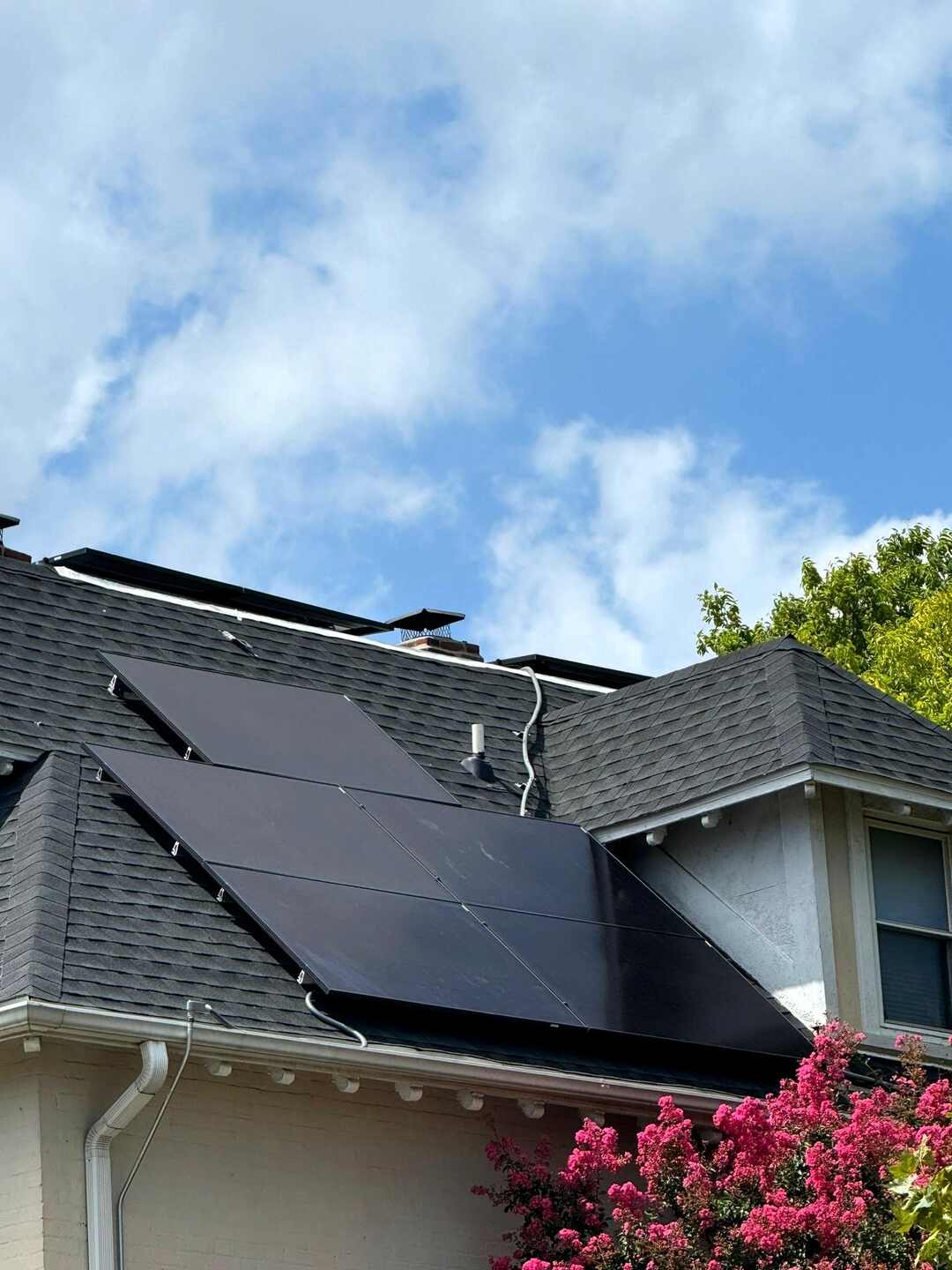 Solar panels on a sloped shingle roof.