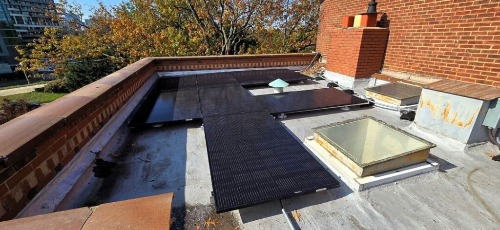 Solar panels on a sunny day with brickwork in the background.