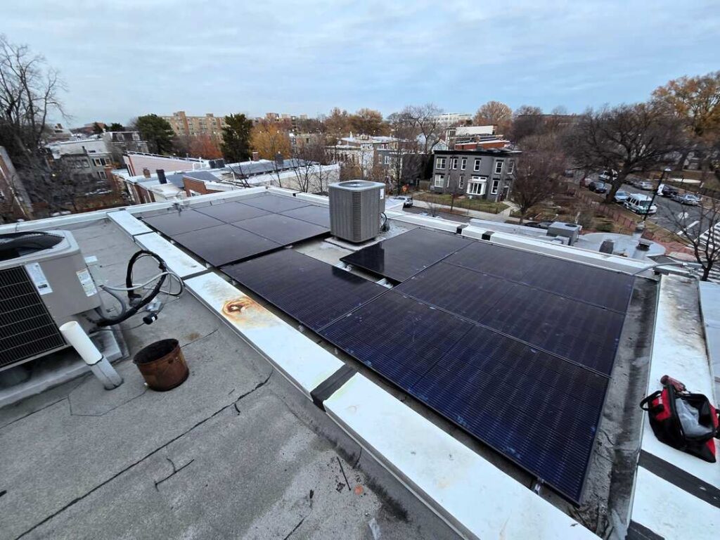 Solar panels on a flat roof under a cloudy sky.