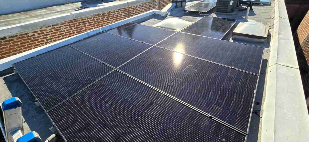 The sun reflected on rooftop solar panels.