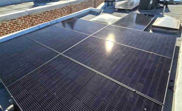 The sun reflected on rooftop solar panels.