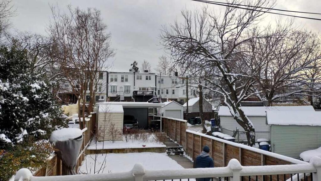 An Uprise Solar installer performs a site visit on a snowy day in Washington, DC.